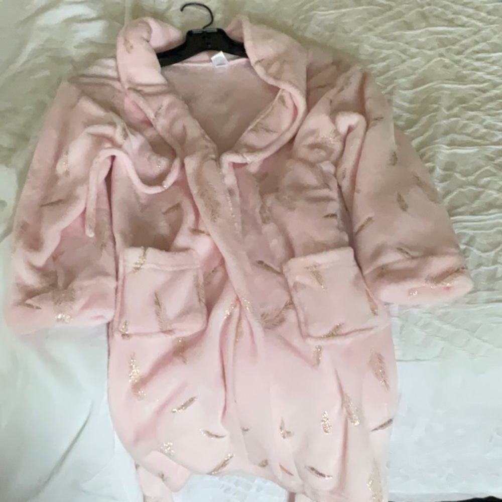 A pink robe with gold feathers in it